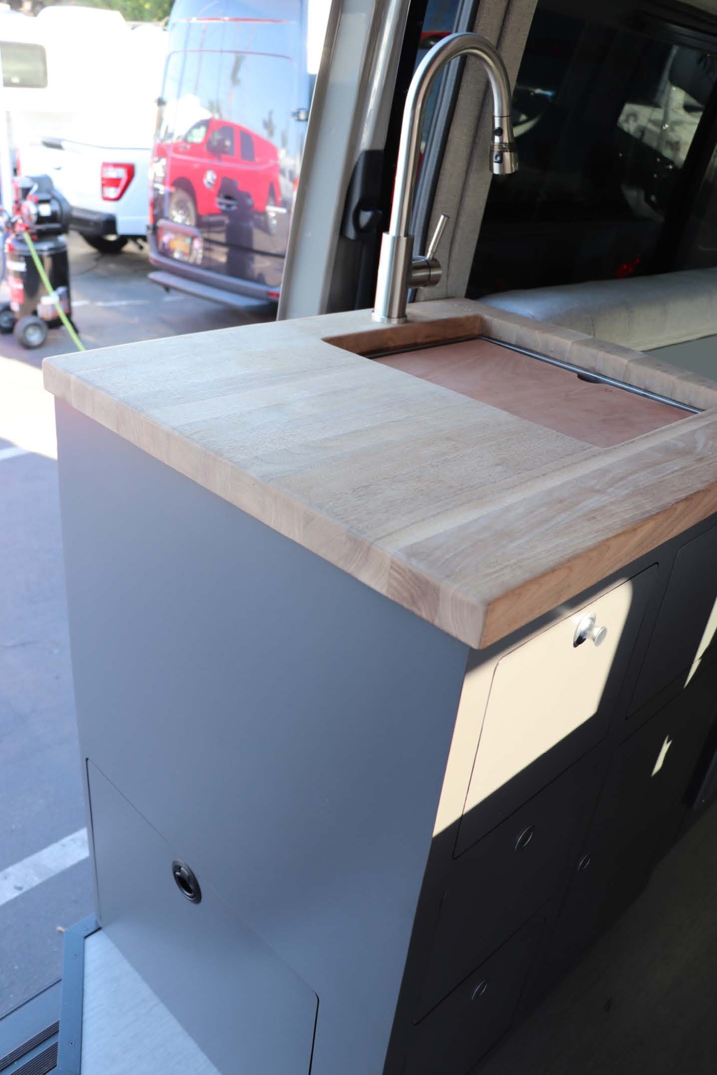 A faucet and sink countertop in a van